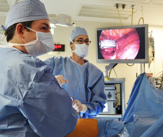 three thoracic surgeons in blue scrubs in operating room