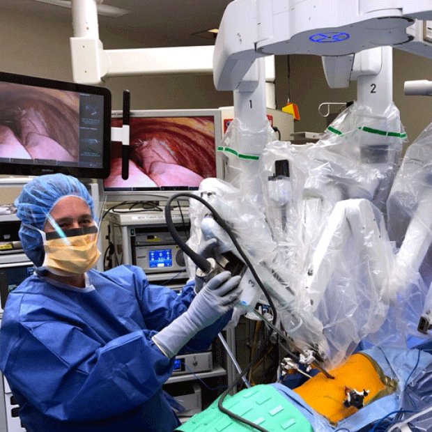 photo of an an assistant at the bedside helping exchange instruments and remove specimens during robotic surgery 