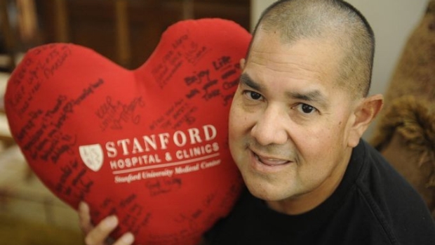 man holding stuffed heart shaped pillow