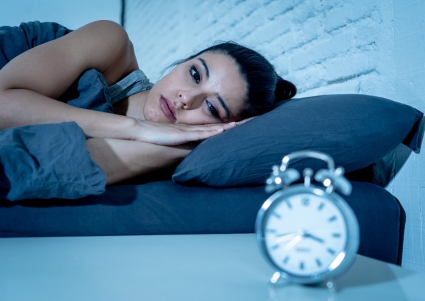 Woman looking at clock; sleep