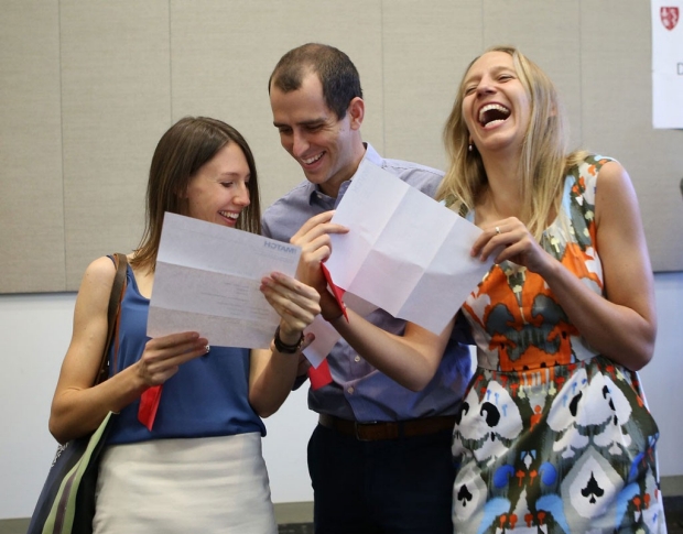 A man between two women as they all reading their Match Day letters