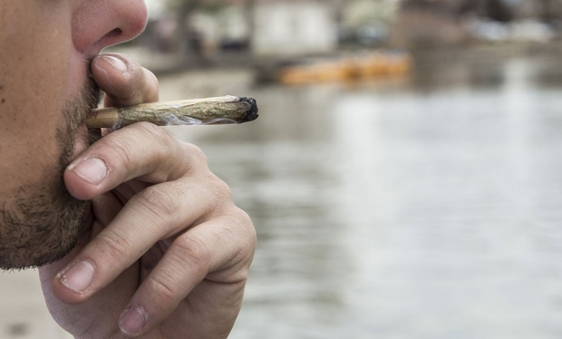 Close-up shot of a man smoking a marijuana joint
