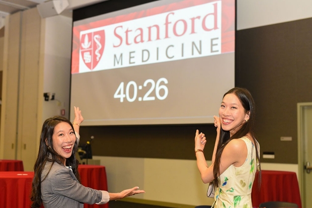 Twin medical students point to the countdown clock for Match Day