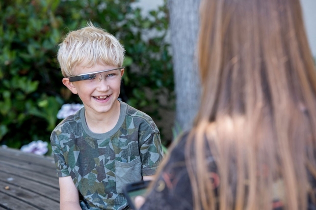 A young boy wearing Google Glass
