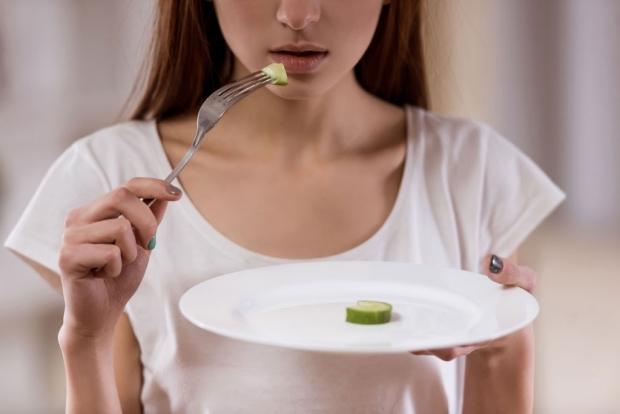 girl eating tiny slice of cucumber